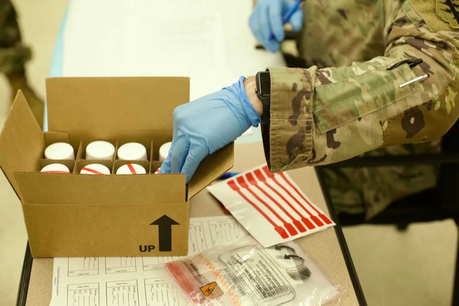 Army urinalysis coordinator reviewing the failed Army drug test bottles.